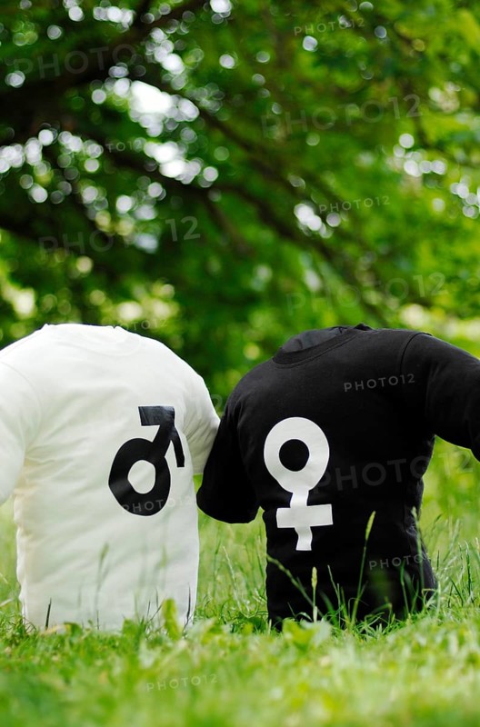 Two T-shirts with the symbols of Mars and Venus on a meadow