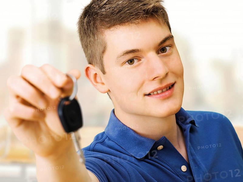 Teenager holding car keys after passing a driving test