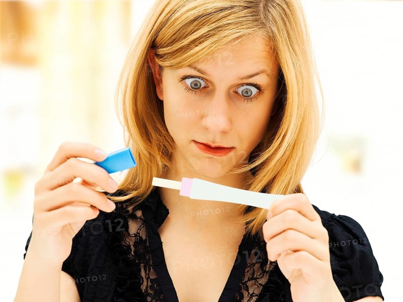 Woman holding a pregnancy test