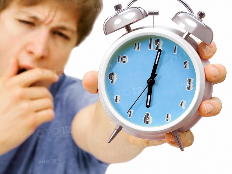 Young man holding an alarm clock