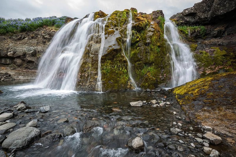 Fossarett waterfall with river Fossa at fjord Hvalfjorour