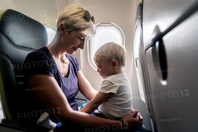 Mother with baby playing in a passenger airplane