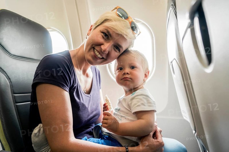 Mother with baby playing in a passenger airplane