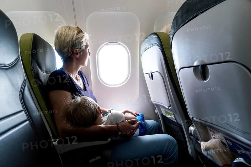 Mother with sleeping baby in a passenger airplane