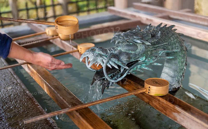 Ritual washing of hands at a sink with dragon figure at a Japanese temple