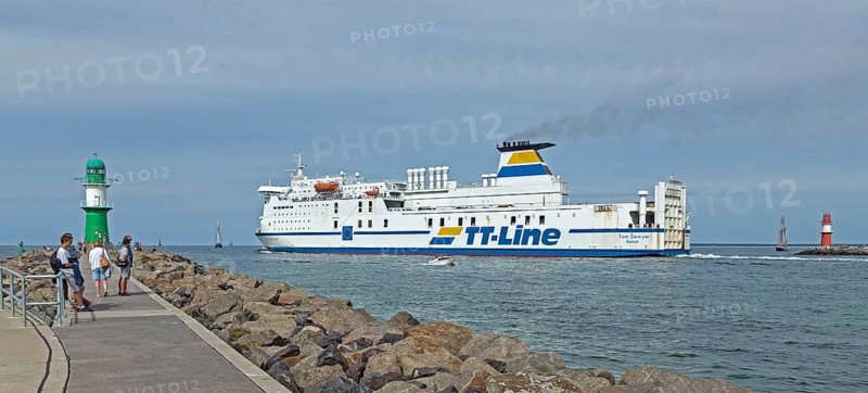 Baltic Sea ferry passes pier light at the entrance to Unterwarnow