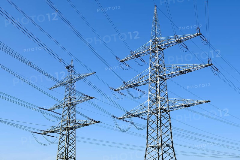 High-voltage pylons in front of a blue sky