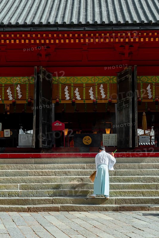 Monk sweeping a staircase with a broom