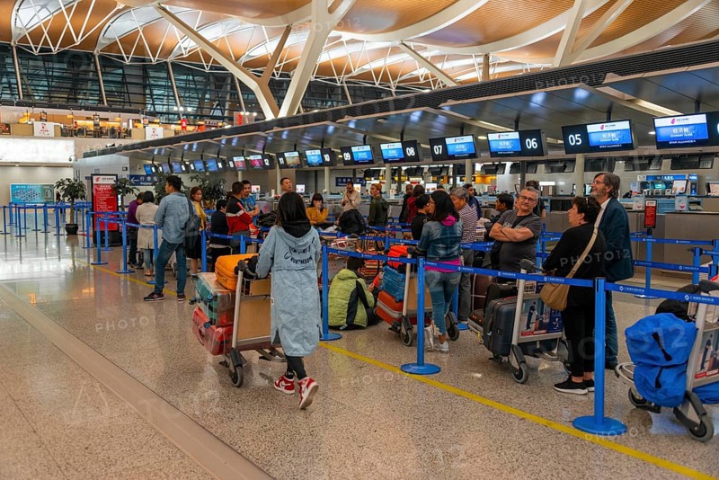 Travellers wait at the counter at the check in