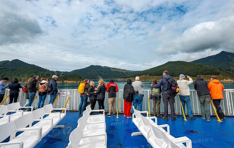 Passengers on deck of a ferry in the fjord