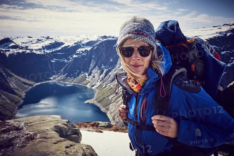 Young woman climbing to Trolltunga
