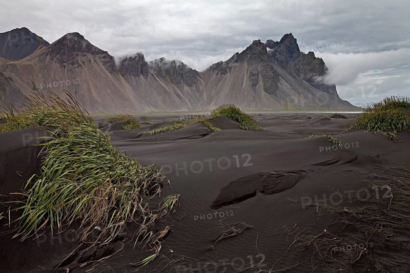Black lava beach with dunes at Cape Stokksnes with mountain Vestrahorn