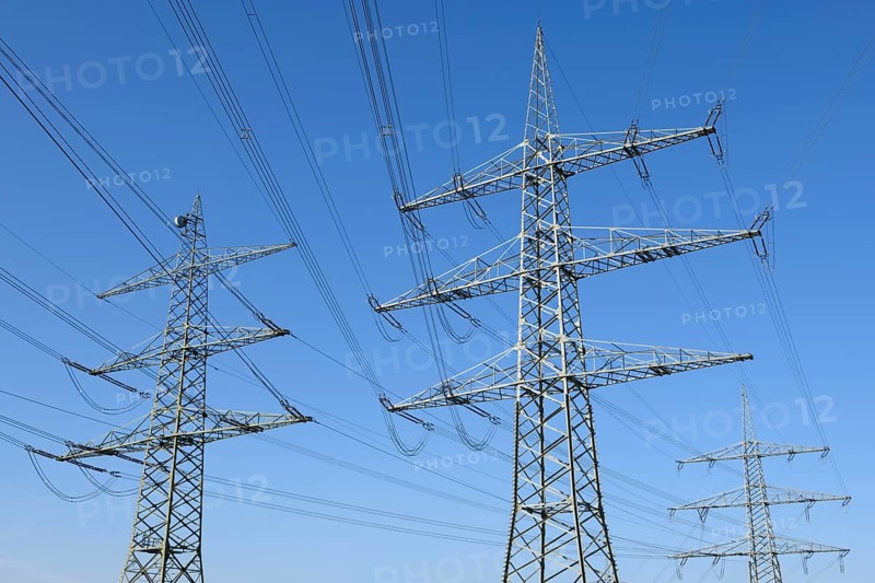 High-voltage pylons in front of a blue sky