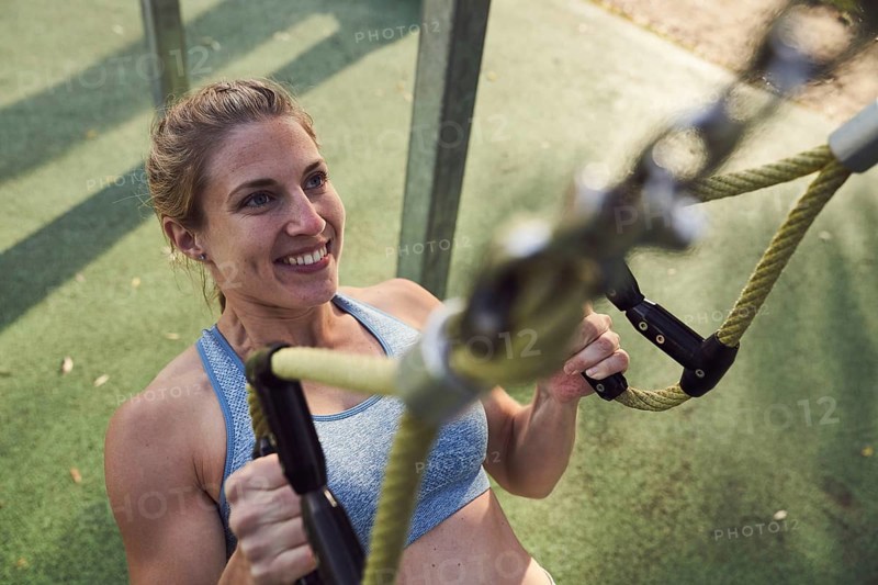 Sporty young woman doing fitness training on the rings