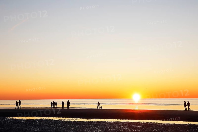 People on the beach at sunset over the North Sea