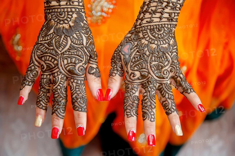 Mehendi tatooed hand of Indian bride on her wedding eve