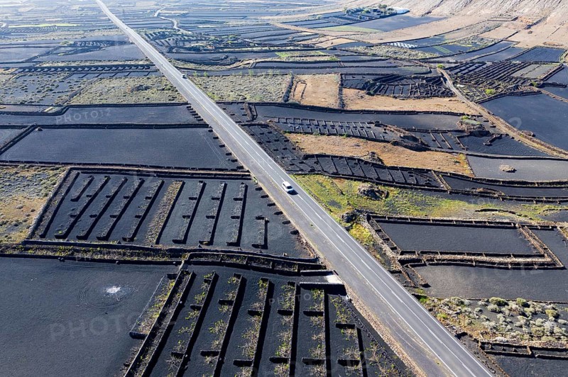 Country road through fields with black lava gravel