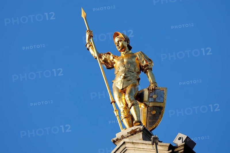 Golden figure with lance on gable of a guild house