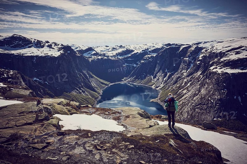 Young woman climbing to Trolltunga