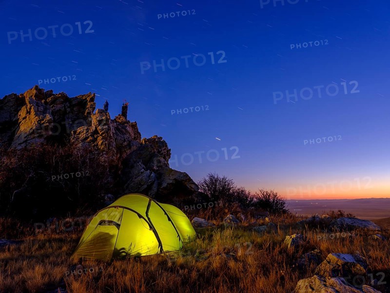 Tent under a rock at dusk
