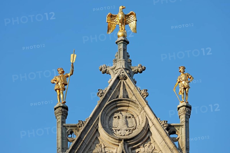 Golden figures with eagle figure on gable of a guild house