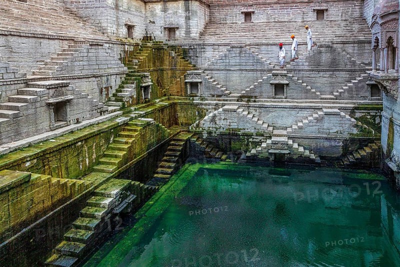 Three men walking down the steps at the stepwell Toorji Ka Jhalra in Jodhpur