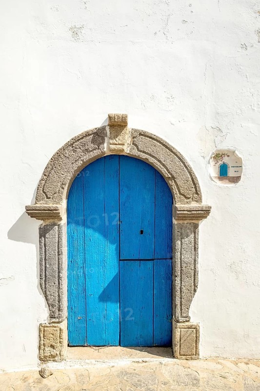 White house wall with blue wooden door