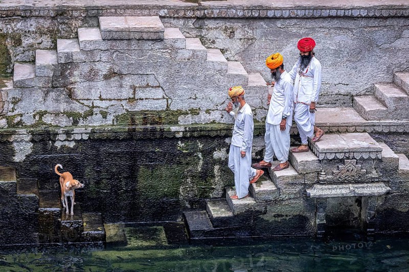 Three men walking down the steps at the stepwell Toorji Ka Jhalra in Jodhpur