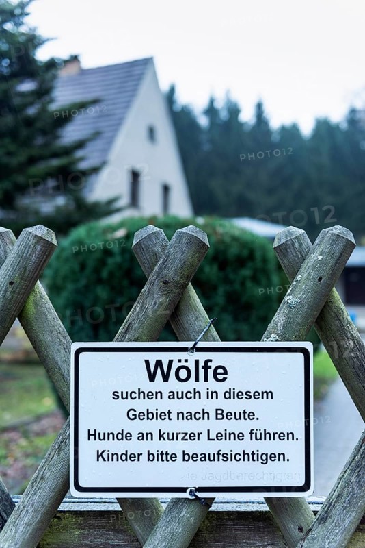 Sign on fence warns of wolves