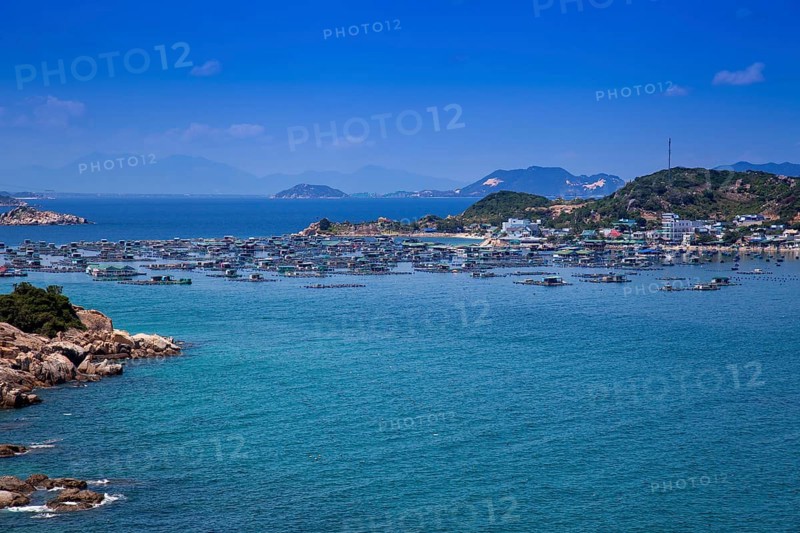 Rocky coastal landscape with floating houses near Vinh Hy