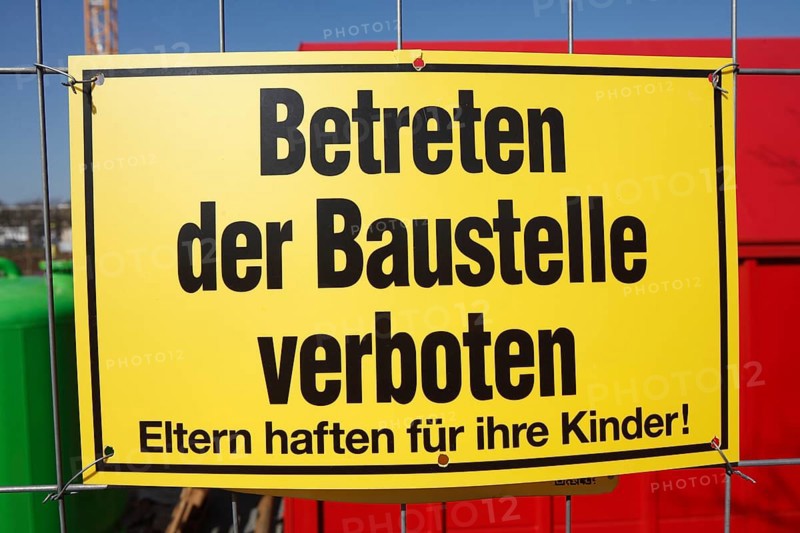 Yellow sign: No one is allowed to enter the building site on a metal grid