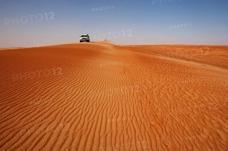 Off-road vehicle and tourist on a sand dunes