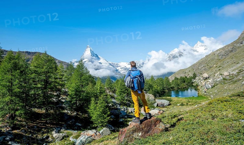 Hiker stands on rocks and looks into the distance