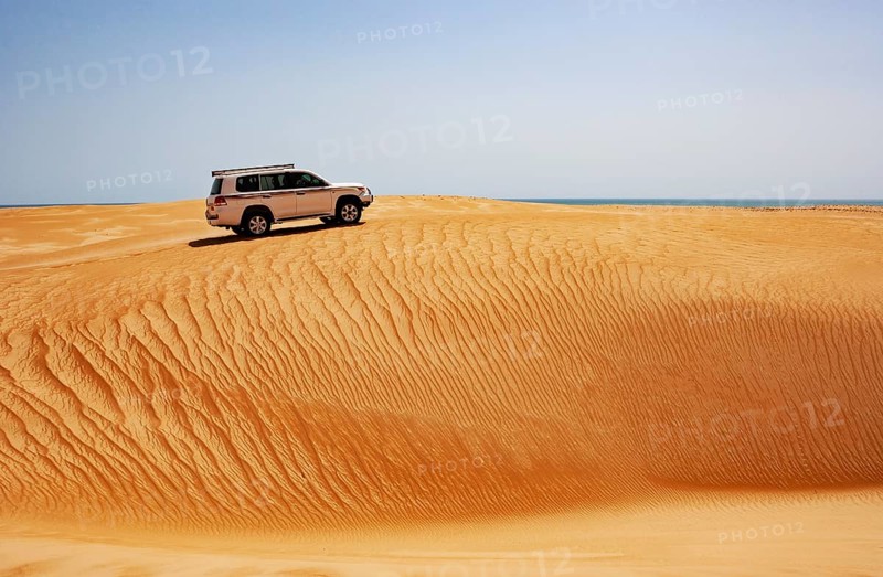 Off-road vehicle drives on sand dune