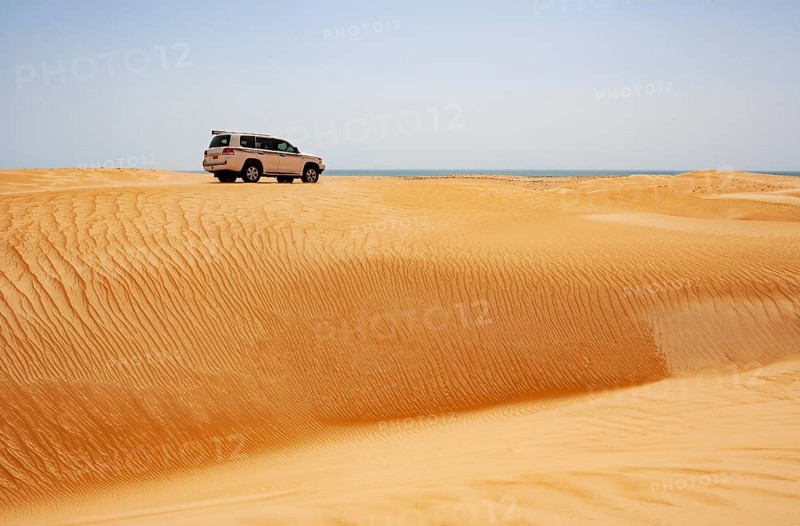 Off-road vehicle drives on sand dune