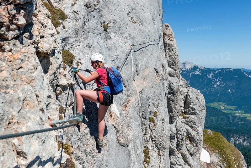 Young woman climbing a rock face