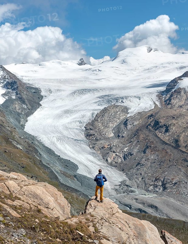Hiker looks from the mountain Unterrothorn onto the glacier tongue of the Findel Glacier