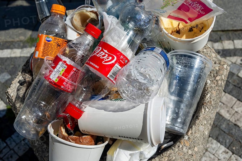 Full rubbish bin with lots of plastic waste and empty plastic bottles