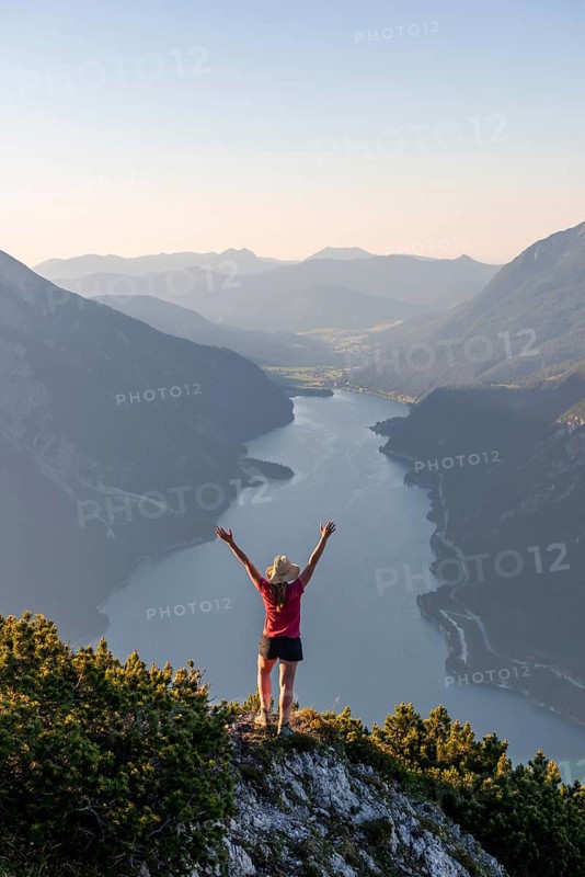 Young woman stretches arms in the air