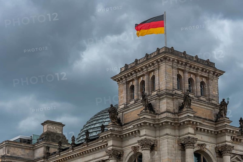 Reichstag with waving German flag at the Spree