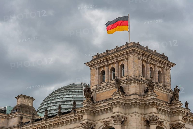 Reichstag with waving German flag at the Spree