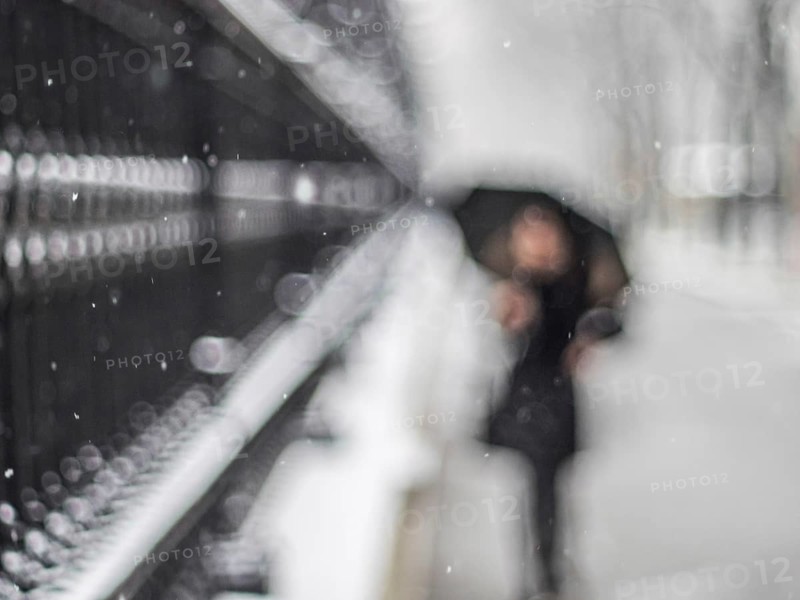 Woman with umbrella walking along a grating