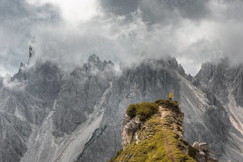 Woman in yellow jacket standing on a ridge