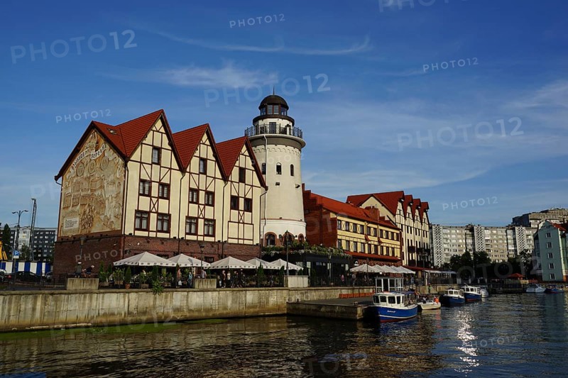Row of houses in the quarter Fischdorf with historical lighthouse at the river Pregel