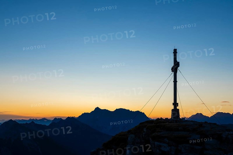 Sunrise with cross of the Thanell summit and Lechtal Alps
