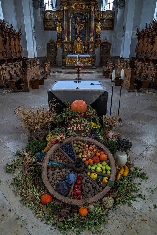 Wagon wheel decorated with vegetables for Thanksgiving in front of the high altar in the church