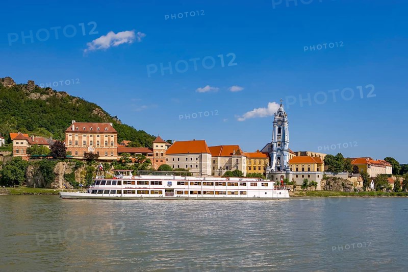 Excursion boat on the Danube in front of the baroque church of the monastery Duernstein