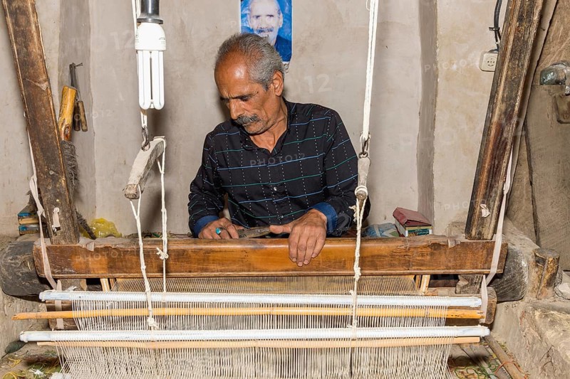 Iranian man working on a loom