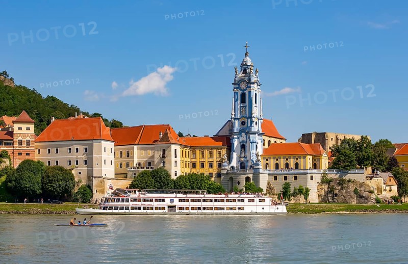Excursion boat on the Danube in front of the baroque church of the monastery Duernstein