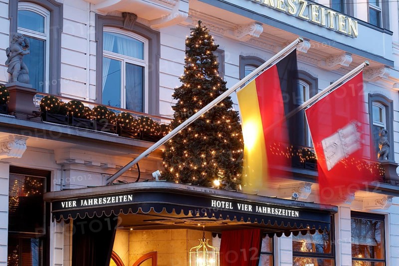 Entrance area with flag of Germany and Hamburg and illuminated christmas tree Hotel Vier Jahreszeiten